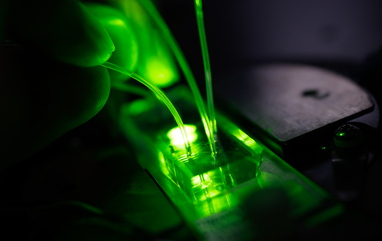 A microfluidic device with green light projecting through it
